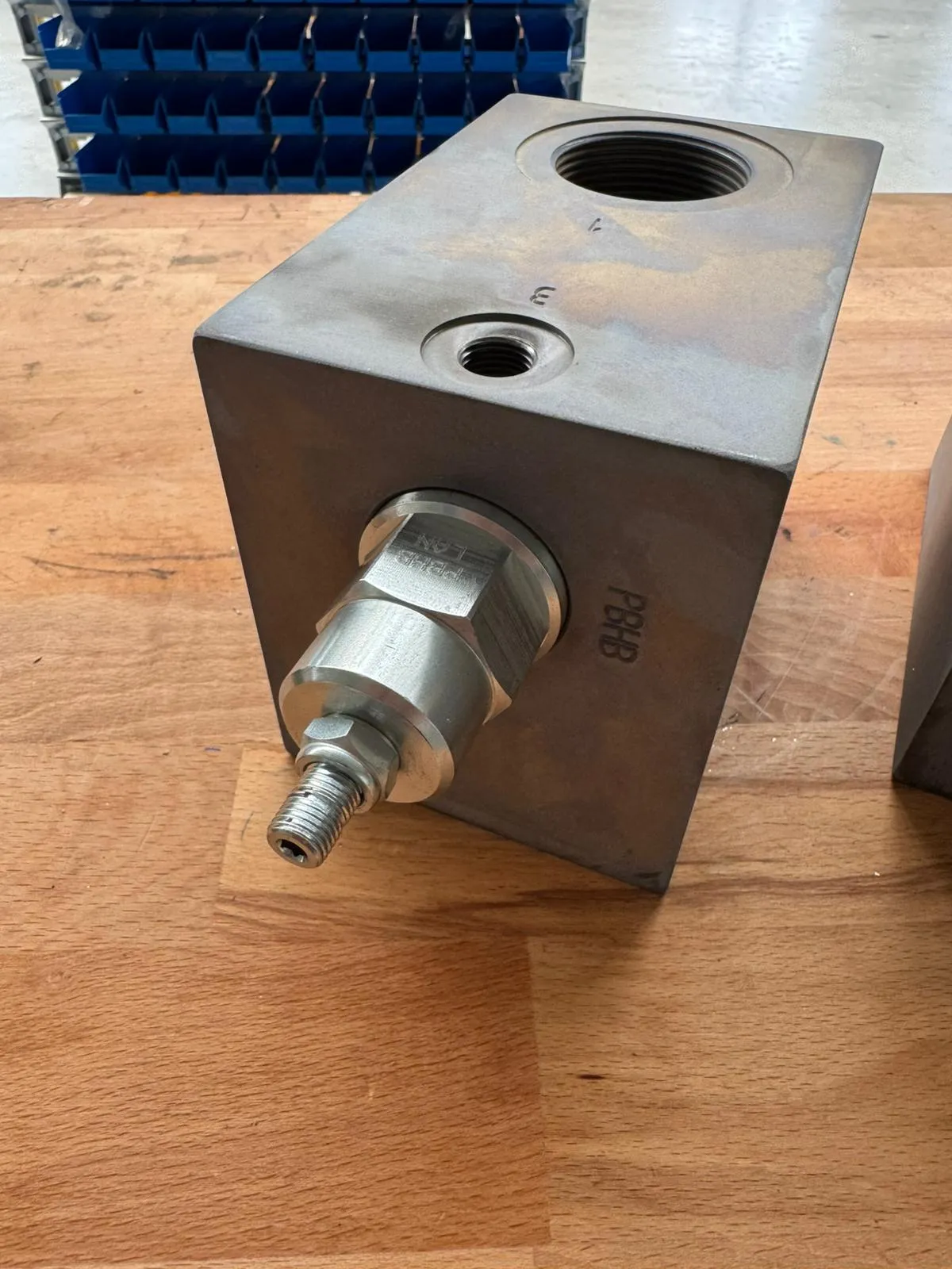 Nahaufnahme eines Steuerblocks mit der eingefrästen Kavitätenbezeichnung PBHB neben dem eingeschraubten Sun-Cartridgeventil und dessen Einstellschraube