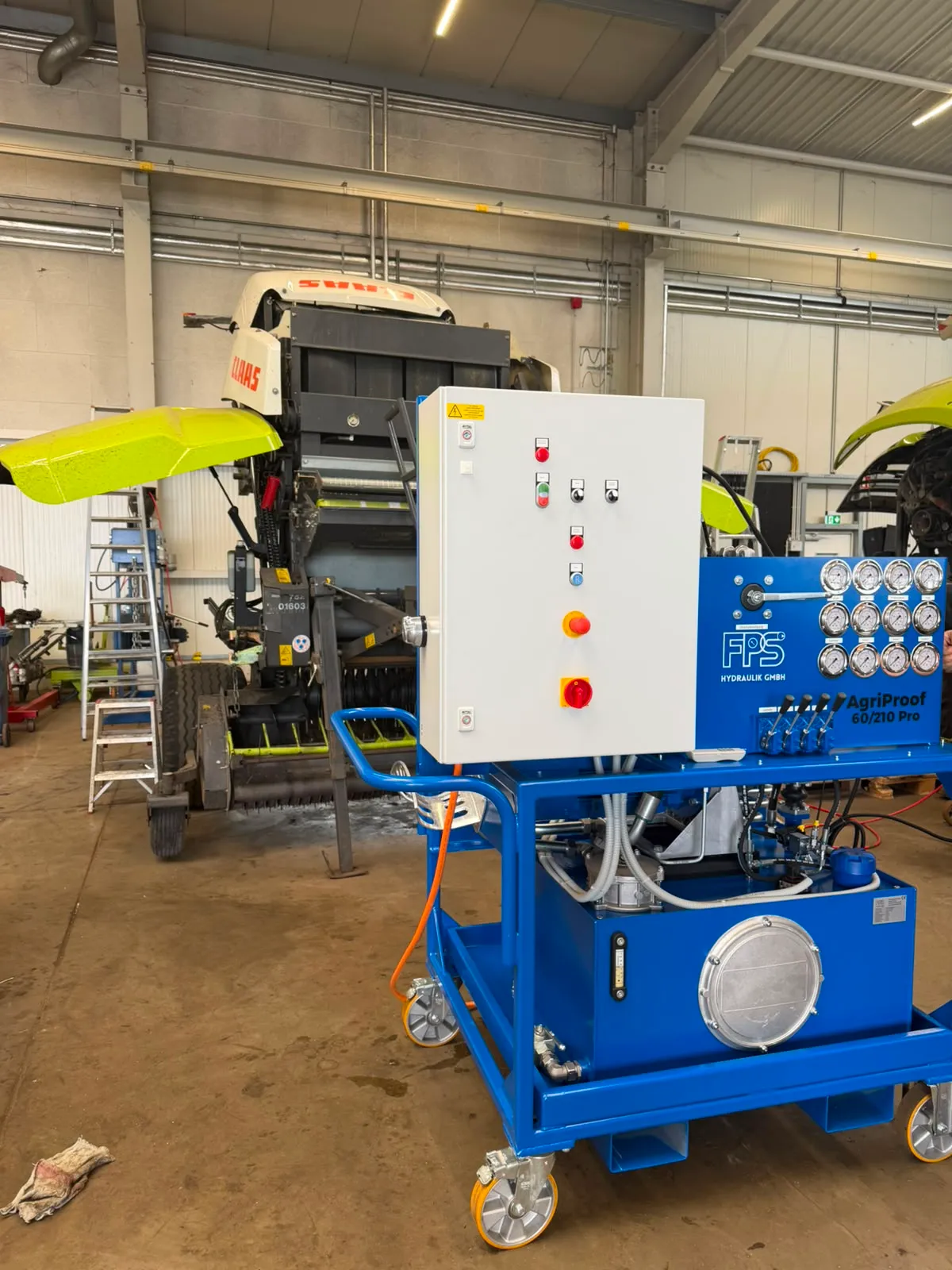 Der AgriProof 60/210 Pro versorgt eine Landmaschine in einer Werkstatthalle mit Hydraulik.